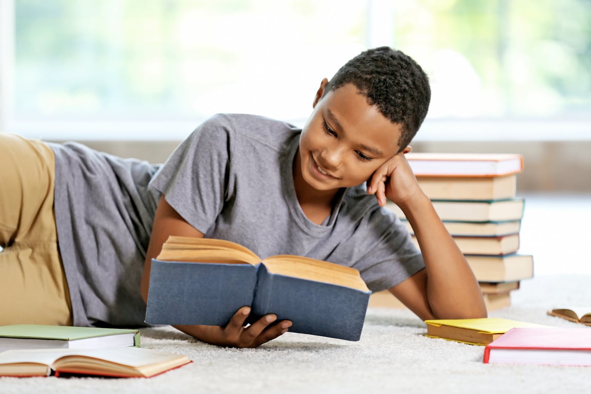 Teenage Boy Reading a Book at Home