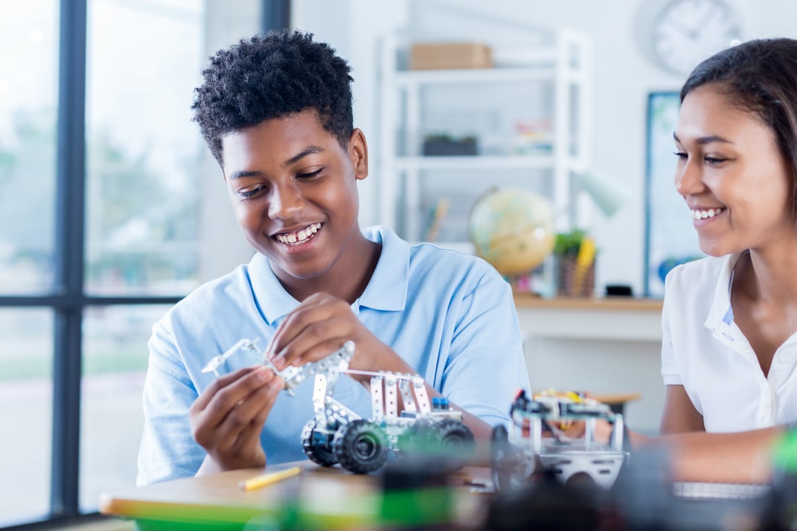 Confident teen STEM students build robotic vehicle